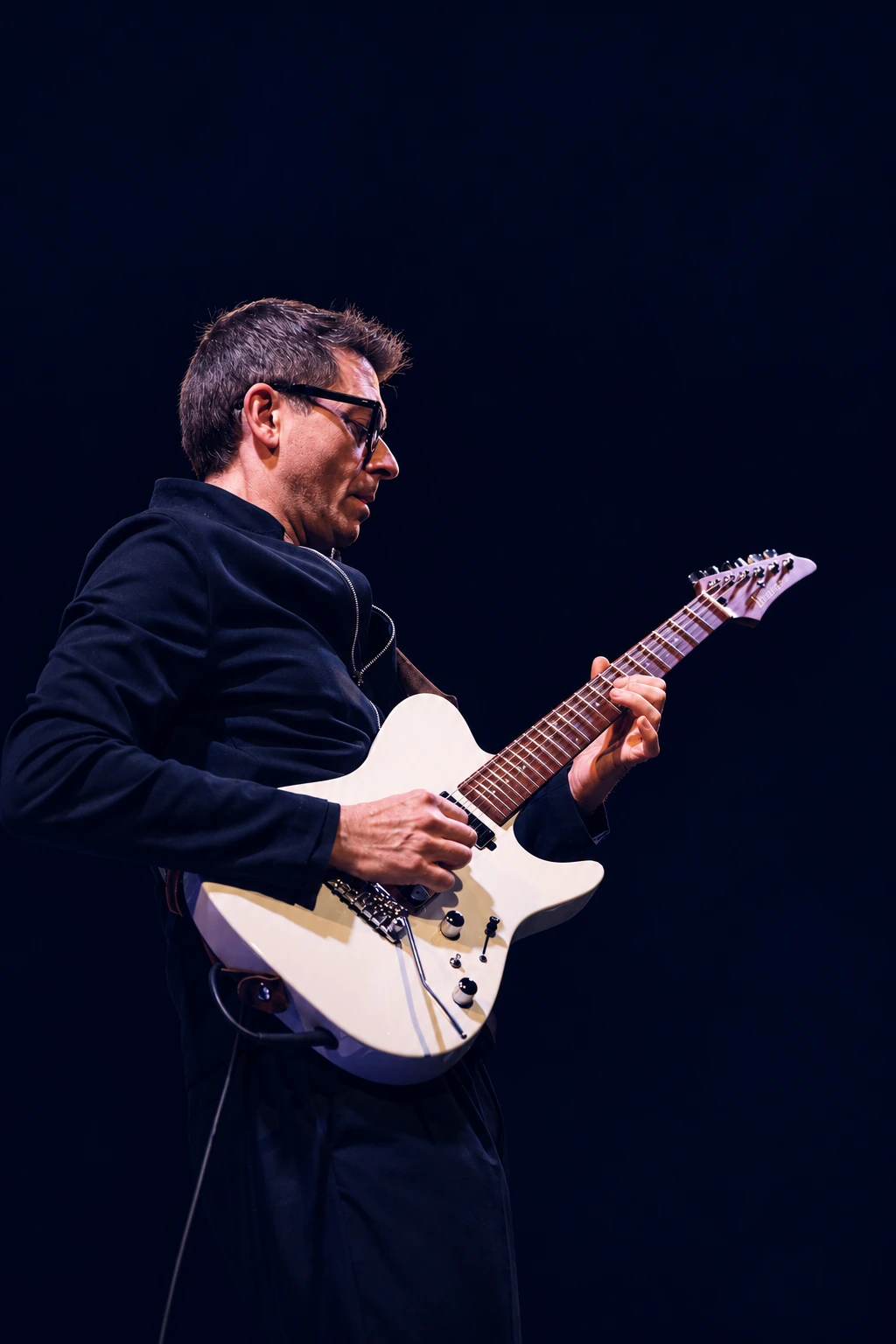 Ivano Icardi performing on stage with his white Ibanez guitar